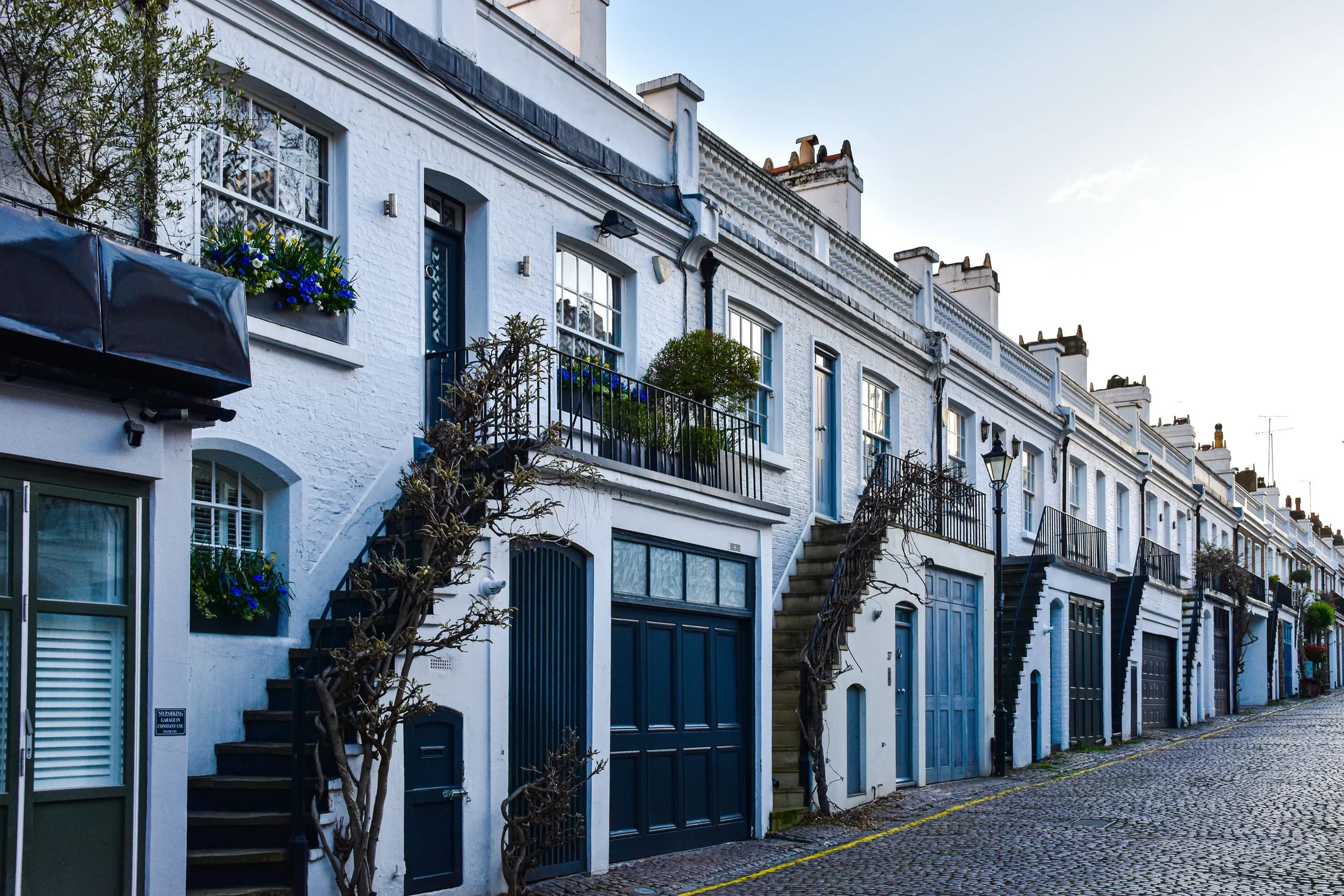 White brick mews homes with blue doors in London, UK