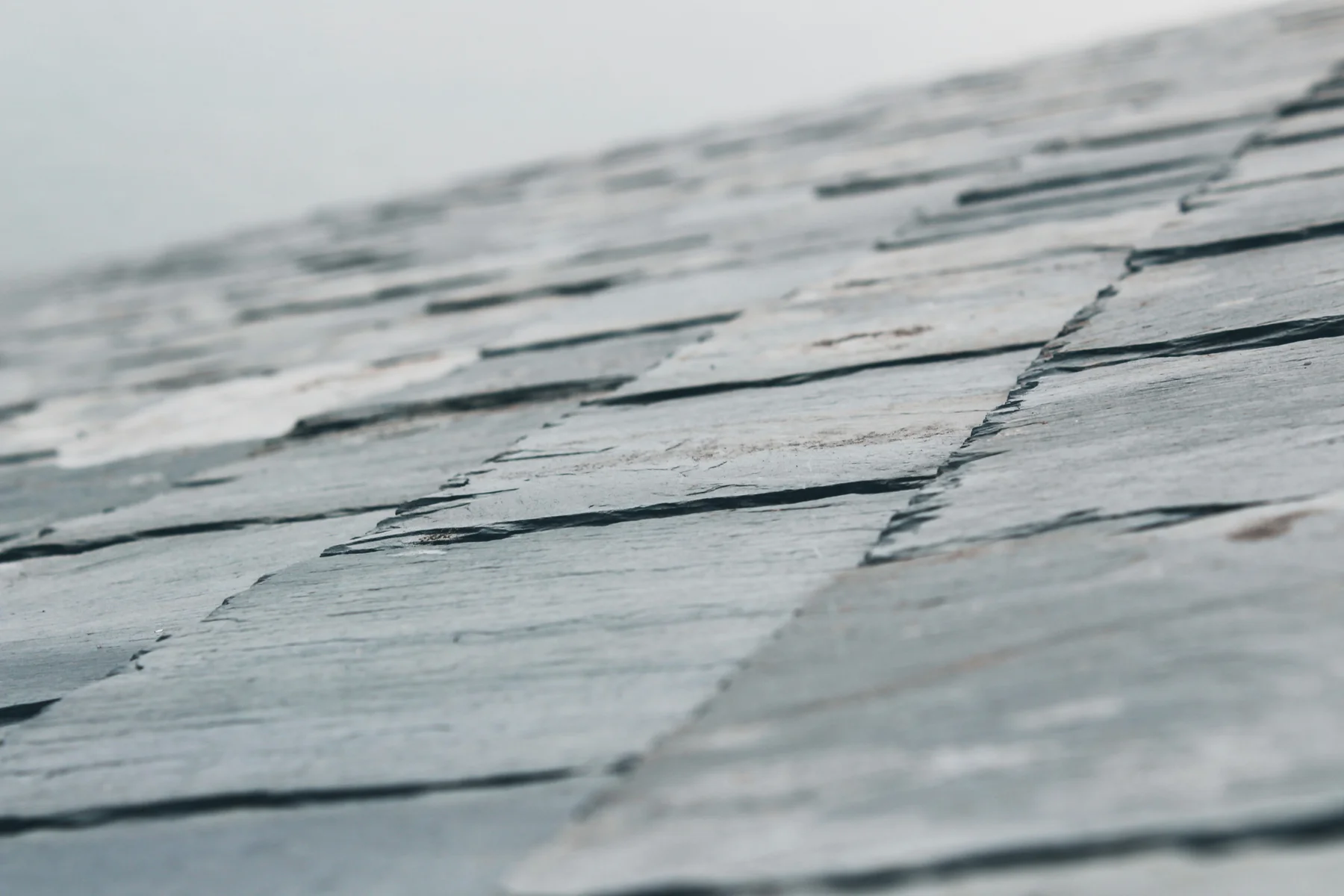 Close-up of overlapping grey slate roof tiles